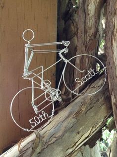 a metal bicycle sculpture sitting on top of a tree