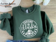 "Alaska Cruise Sweatshirt, Family Cruise Hoodies, Cruise Squad, Cruise Travel Sweater, Alaska Family Trip, Cruise Sweatshirt,Mountain Sweater - How To Order ----- 1-) Please, check and review all the photos. 2-) Choose your t-shirt size and color. *We use more than one brand product. Different styles of shirts may have different shades of same color choice due to different manufacturer brands. *For this reason, we recommend you to match shirts from the same styles if you want precisely matching Green Long Sleeve Sweatshirt For Outdoor Activities, Winter Hiking Crew Neck Top, Long Sleeve Fleece Top For Hiking, Green Fleece Tops For Outdoor Activities, Green Fleece Top For Outdoor Activities, Winter Adventure Long Sleeve Sweatshirt, Winter Adventure Crew Neck Sweatshirt, Winter Crew Neck Sweatshirt For Adventure, Long Sleeve Letter Print Sweater For Outdoor