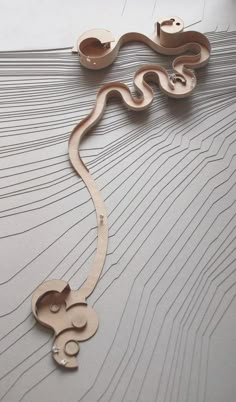 an intricately carved piece of wood is displayed on a white surface with wavy lines in the background