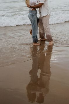 a man and woman embracing on the beach