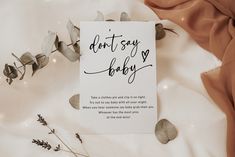 a card that says don't say baby on it next to some dried leaves