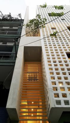 an apartment building with wooden slats on the side and plants growing out of it