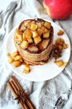 a stack of pancakes with apples and cinnamon on top