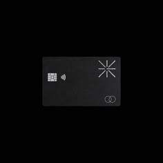 a black credit card with white symbols on it's front and back side, against a dark background