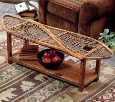 a coffee table with a surfboard on it and some apples in a bowl next to it