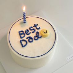 a birthday cake with the words best dad written on it and a smiley face candle