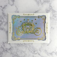 a white and blue card with a gold crown on the front, sitting on a marble surface