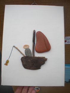 a piece of paper with some rocks and sticks on it in the shape of a leaf