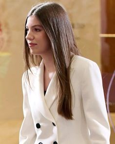 a woman with long hair wearing a white suit