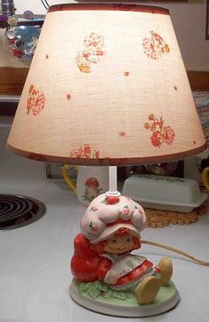 a lamp that is sitting on top of a table with a teddy bear underneath it