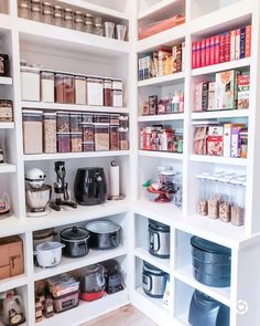 an organized pantry with white shelving and lots of food on the counter top in front of it