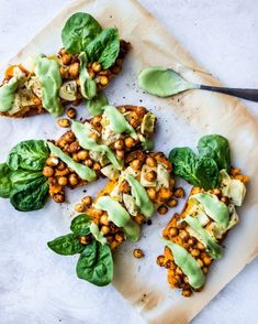 spinach, chickpeas and avocado salad on a white plate with a spoon