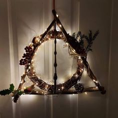 a christmas wreath hanging from the ceiling with lights and decorations on it's sides