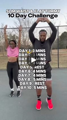 two people standing on a tennis court with their arms in the air