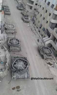 an aerial view of some buildings and construction equipment in the middle of a city street