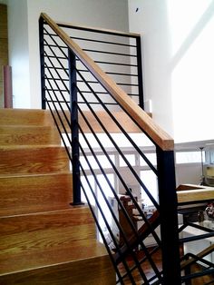 there is a stair case in the middle of this room with wood and metal railings