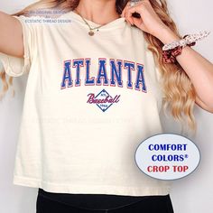 This is an original Ecstatic Thread Design featuring a vintage distressed style Atlanta Baseball cozy Comfort Colors® Boxy Crop Top T-Shirt. Makes a great gift for the Atlanta baseball fan! See our matching Comfort Colors® short sleeve shirt: https://ecstaticthreaddesign.etsy.com/listing/1692648124  And our matching sweatshirt: https://ecstaticthreaddesign.etsy.com/listing/1695513500  - This is a boxy fit cropped tee, please see size dimensions if you would like to order up for a loose or baggy Sporty Distressed White Tops, Vintage Atlanta, Boxy Crop Top, Thread Design, Colorful Crop Tops, Matching Sweatshirts, Cropped Shirt, Comfort Colors Shirt, Baseball Fan