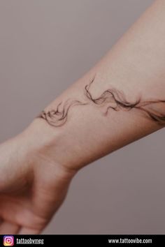 a woman's arm with a wave tattoo on it