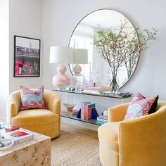 a living room filled with furniture and a large round mirror