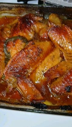 a casserole dish with meat and vegetables in it sitting on a stove top