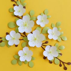 paper flowers are arranged on a yellow surface