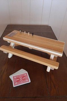 a wooden bench with matches on it next to a playing card