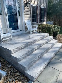 a white chair sitting on top of a set of steps next to a door and window