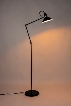 a black floor lamp with a white light on it