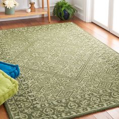 a green rug with an intricate design on the floor