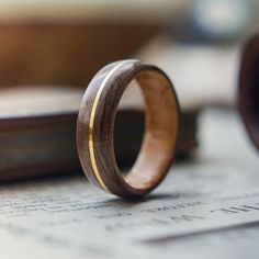 a wooden ring sitting on top of a piece of paper next to an open book