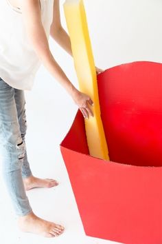 a woman standing in front of a red box with yellow tape sticking out of it