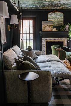 a living room filled with furniture and a painting on the wall above the fire place