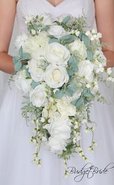 a bride holding a bouquet of white flowers