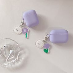 two ear buds are sitting next to each other on a white table with a glass bowl