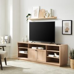 a flat screen tv sitting on top of a wooden entertainment center in a living room