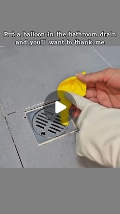 a person using a yellow blow dryer on the floor next to a drain hole