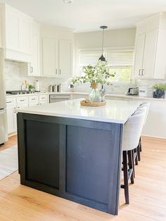 a kitchen with white cabinets and an island