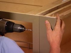 a person using a drill to fix a drawer