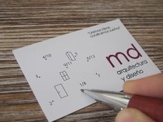 a person is holding a pen and writing on some paper with the word m d