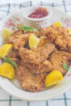 fried chicken with lemons and ketchup on a plate