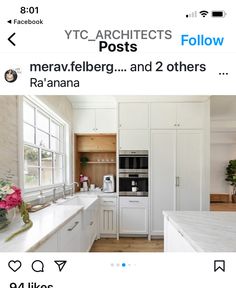 an image of a white kitchen with lots of counter space and flowers in the window