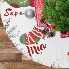 a christmas themed placemat with presents and pine cones on it next to a fir tree