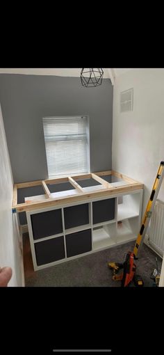 an unfinished kitchen counter being built in the corner of a room with gray walls and white cabinets