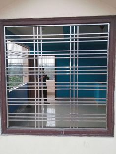 a person standing in front of a window with bars on it