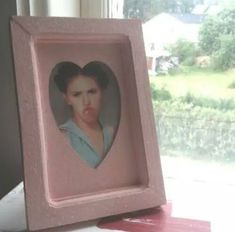 a pink frame with a picture of a woman's face in the shape of a heart