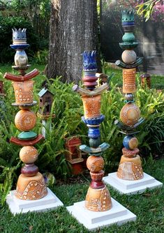 a group of vases sitting on top of each other in front of a tree