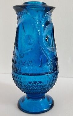 a blue glass vase sitting on top of a table