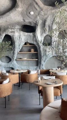 the interior of a restaurant with tables, chairs and plants in pots on the wall