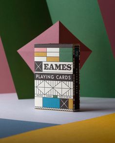 a card game box sitting on top of a table next to a colorful geometric background