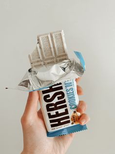 a hand holding a hershey bar wrapped in foil